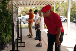 BBQ-older-gentleman-bends-at-waist-examining-photo-board-closer_thumb